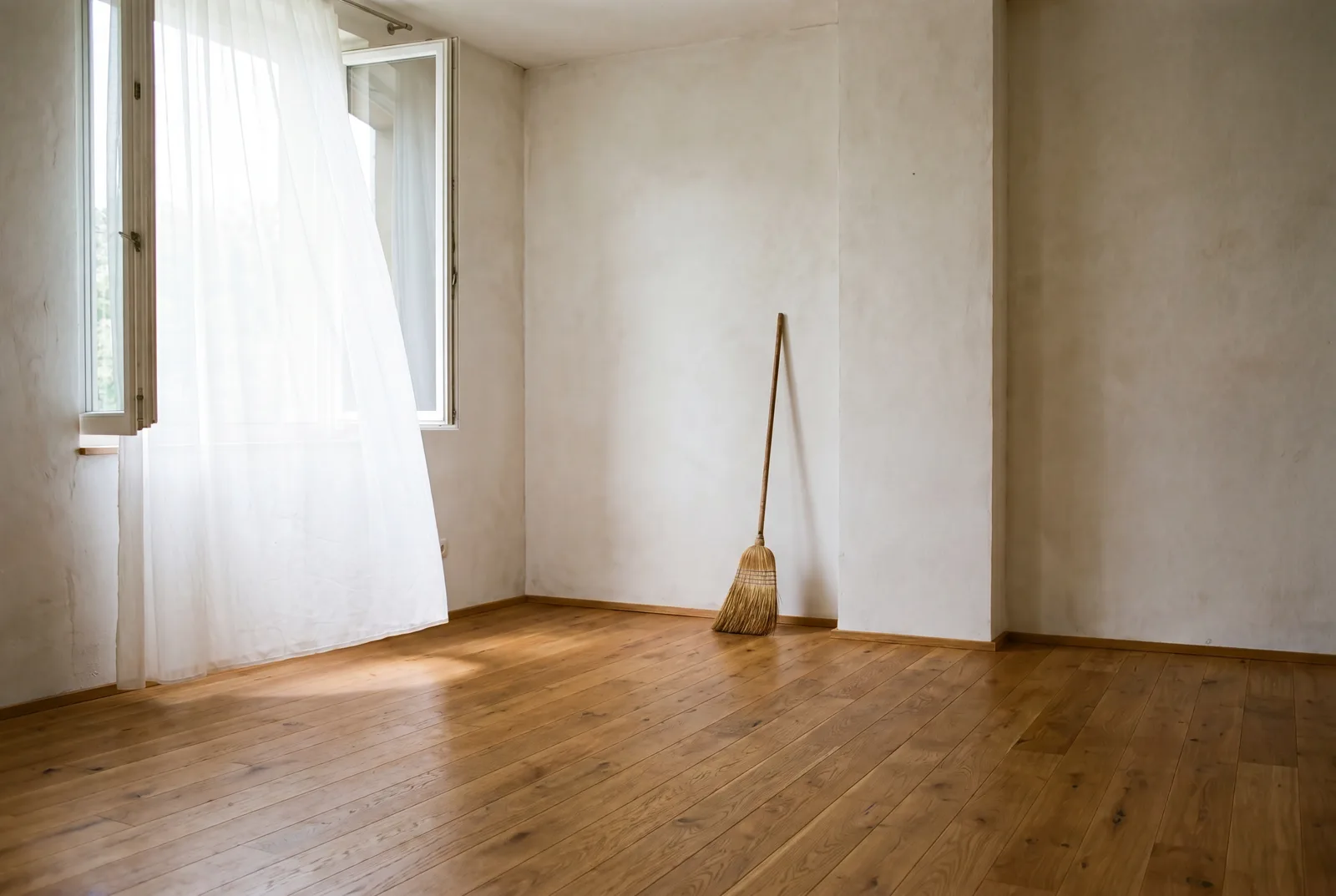 Empty, broom-clean room filled with bright daylight